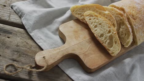 video of bread on chopping wooden board on wooden worktop