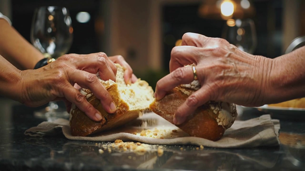 Increasing pressure, two pairs of hands pressing and pulling loaf on kitchen counter, sharing meal