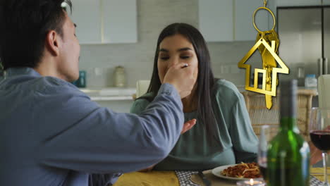 animación de la llave de la casa de oro y el llavero sobre una pareja feliz y diversa comiendo en casa
