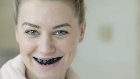 A-pretty-woman-looks-at-the-camera-and-then-smiles-revealing-black-teeth