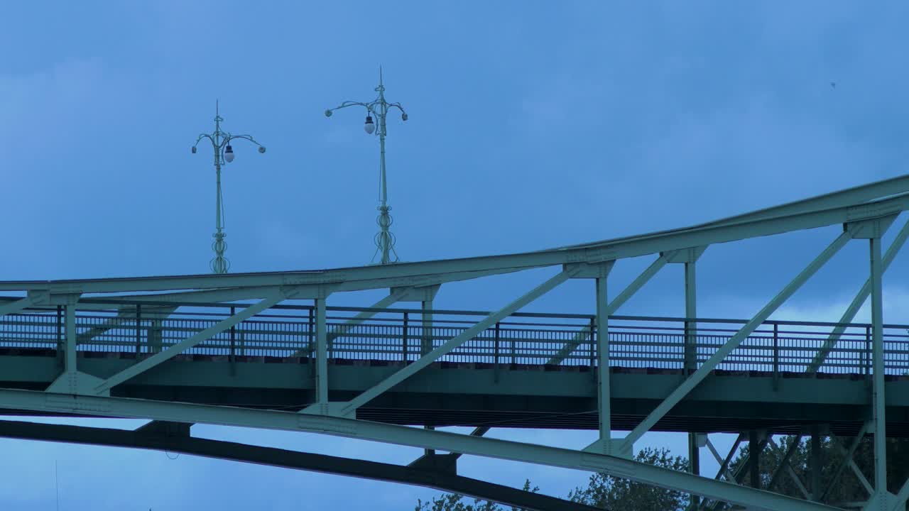 저녁에 리파자 시에 있는 오스카라 칼파카 스윙 다리 위로 빠르게 움직이는 짙은 회색 비구름, 중간 샷