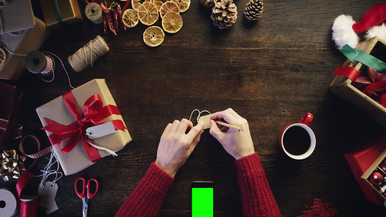 vista superior manos de navidad wrting nombre en etiqueta de regalo utilizando pantalla táctil desde arriba - dragón épico rojo