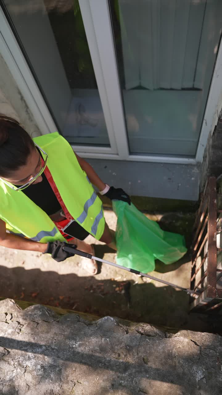 Woman Cleaning Up Trash in a Residential Area