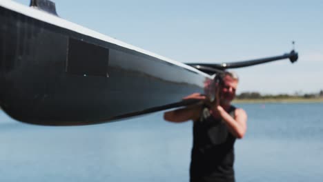 senior caucasian man carrying a rowing boat