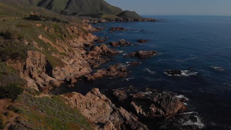 Sunset-over-rocky-cliff-and-rolling-hills-in-Northern-California,-Big-sur