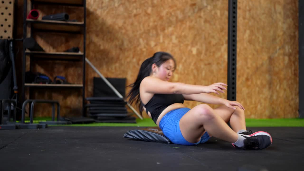 Woman doing sit-ups in the gym