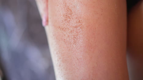 mujer hace masaje anti-celulitis del muslo usando exfoliante de café