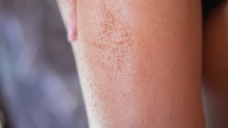 woman makes thigh anti-cellulite massage using coffee scrub