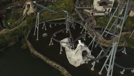 a high-speed rollercoaster racing by the lake in an amusement park during the summer in poland