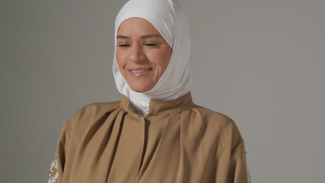 Retrato-De-Estudio-De-Una-Mujer-Musulmana-Sonriente-Usando-Hijab-Contra-Un-Fondo-Liso