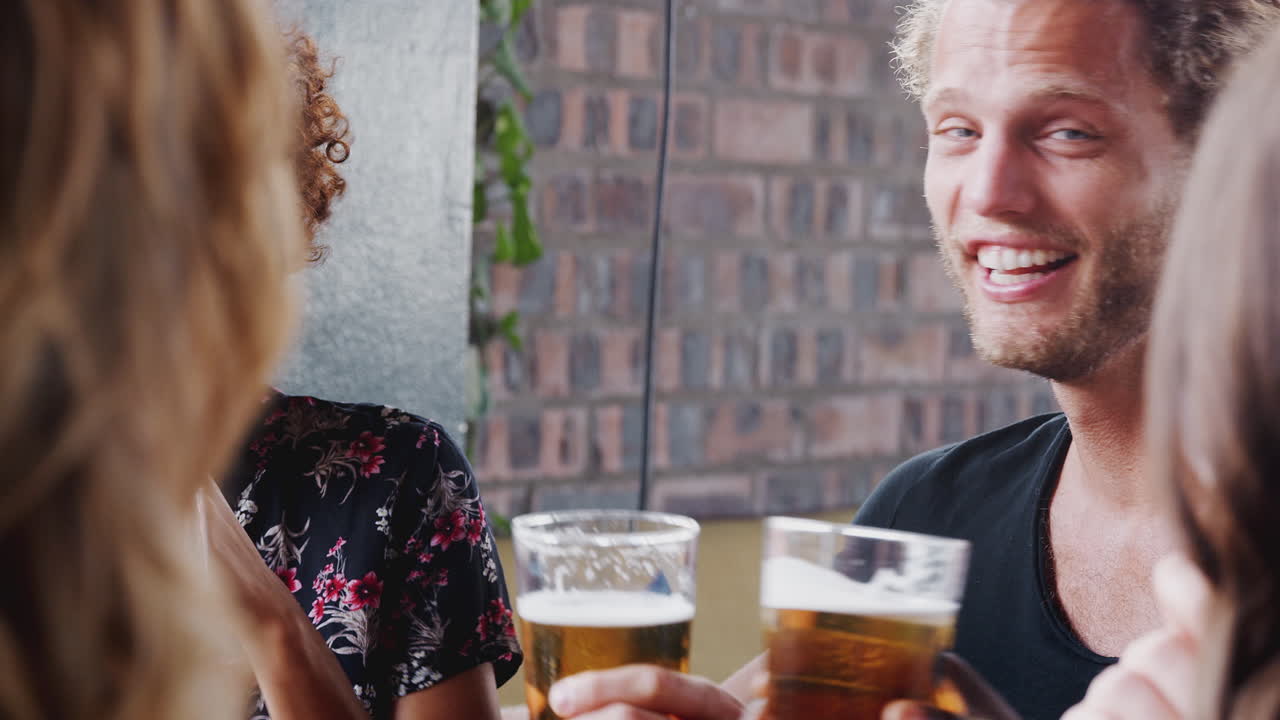 Group Of Young Friends Meeting For Drinks And Food Making A Toast In Restaurant