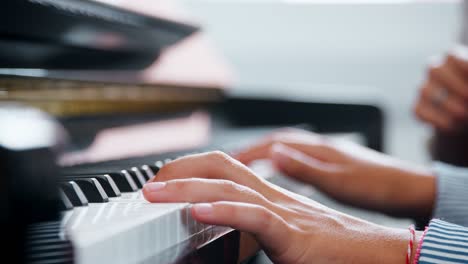 primer plano del alumno con el maestro tocando el piano en la lección de música