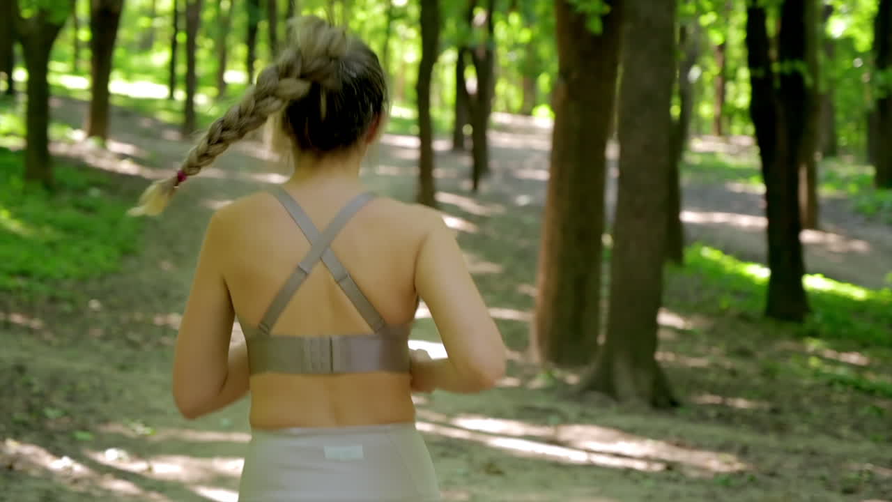Woman in beige sportswear working out in the park