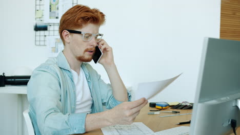 Architect Talking on Phone and Reviewing Plans