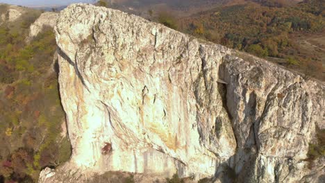 panorámica aérea toma en ángulo alto de una gran roca alta al borde de una montaña-7