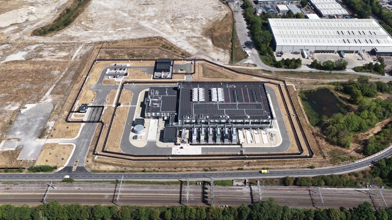 Veduta aerea con drone dall'alto di un'enorme struttura di data center dotata di unità di raffreddamento HVAC, sottostazioni elettriche e architettura moderna che alimenta reti cloud e sistemi di intelligenza artificiale