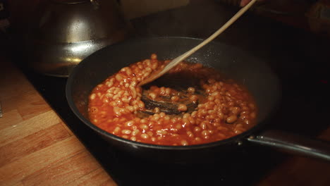 Freír-Los-Frijoles-En-Salsa-De-Tomate-En-Una-Sartén-Caliente