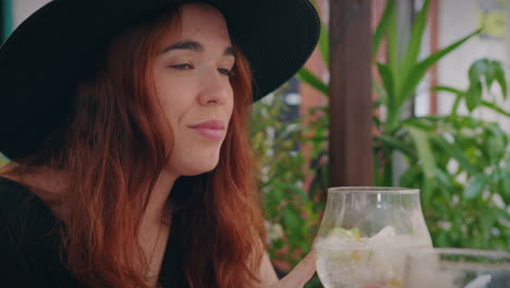 girl-relaxes-on-a-bar-terrace-and-drinks-a-gin-medium-shot