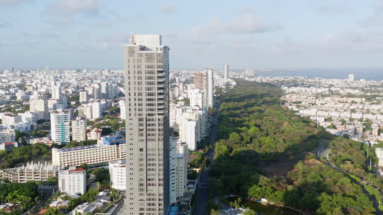 vista aérea panorámica del horizonte de la ciudad del alto rascacielos residencial de la avenida anacaona y el centro de santo domingo y vista del agua del mar en un día soleado, república dominicana, descenso de drones aéreos