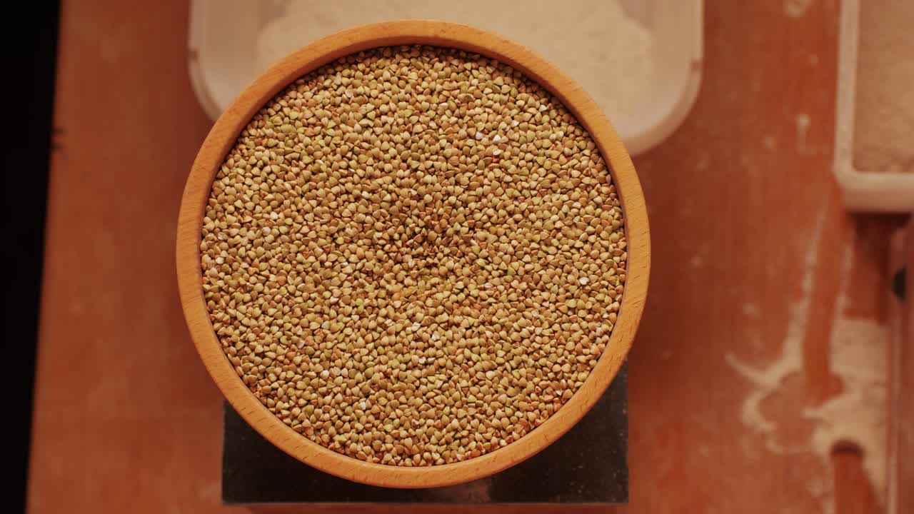 Close-up shot of treatment of seeds of cereals: rye, barley, wheat against diseases and insects using modern equipment. Hard wheat in hopper being ground into whole wheat flour. High quality 4k footage