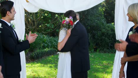 Happy-smiling-bride-and-groom-hugging-each-other-and-people-are-clapping-4K-4k