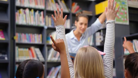 maestra caucásica que enseña a los escolares en la biblioteca de la escuela 4k