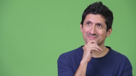 hispanic man thinking against green background
