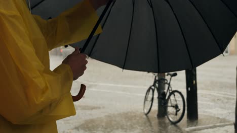 business man tourist person with umbrella and raincoat on rainy european city street, lights reflecting, walking in barcelona or amsterdam during the rain