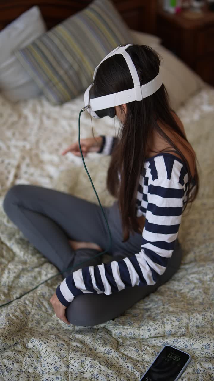 chica adolescente usando auriculares de realidad virtual en la cama