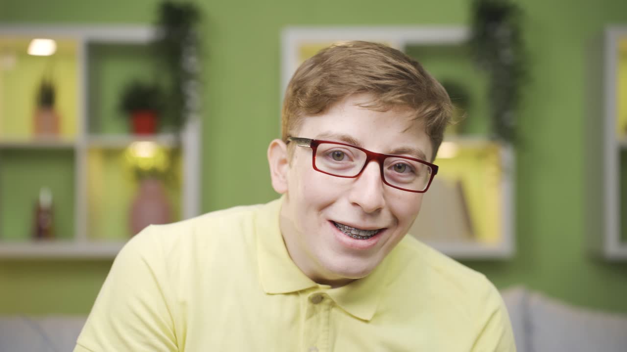 가까운 장면에서 장난스러운 젊은이가 카메라를 쳐다보며 춤을 추고 있습니다.