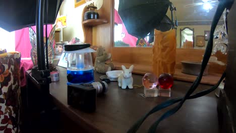 una gran cantidad de objetos y adornos en una mesa de madera frente a un espejo en una sala de estar
