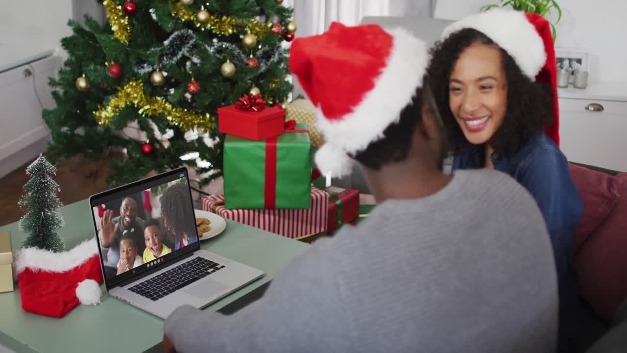 feliz pareja afroamericana en videollamada en computadora portátil con la familia en tiempo de navidad