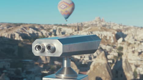 binoculars at aşıklar tepesi overlooking hot air balloon at cappadocia