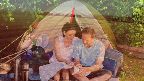 pareja de campamento leyendo un mapa sobre un paisaje pintoresco y árboles