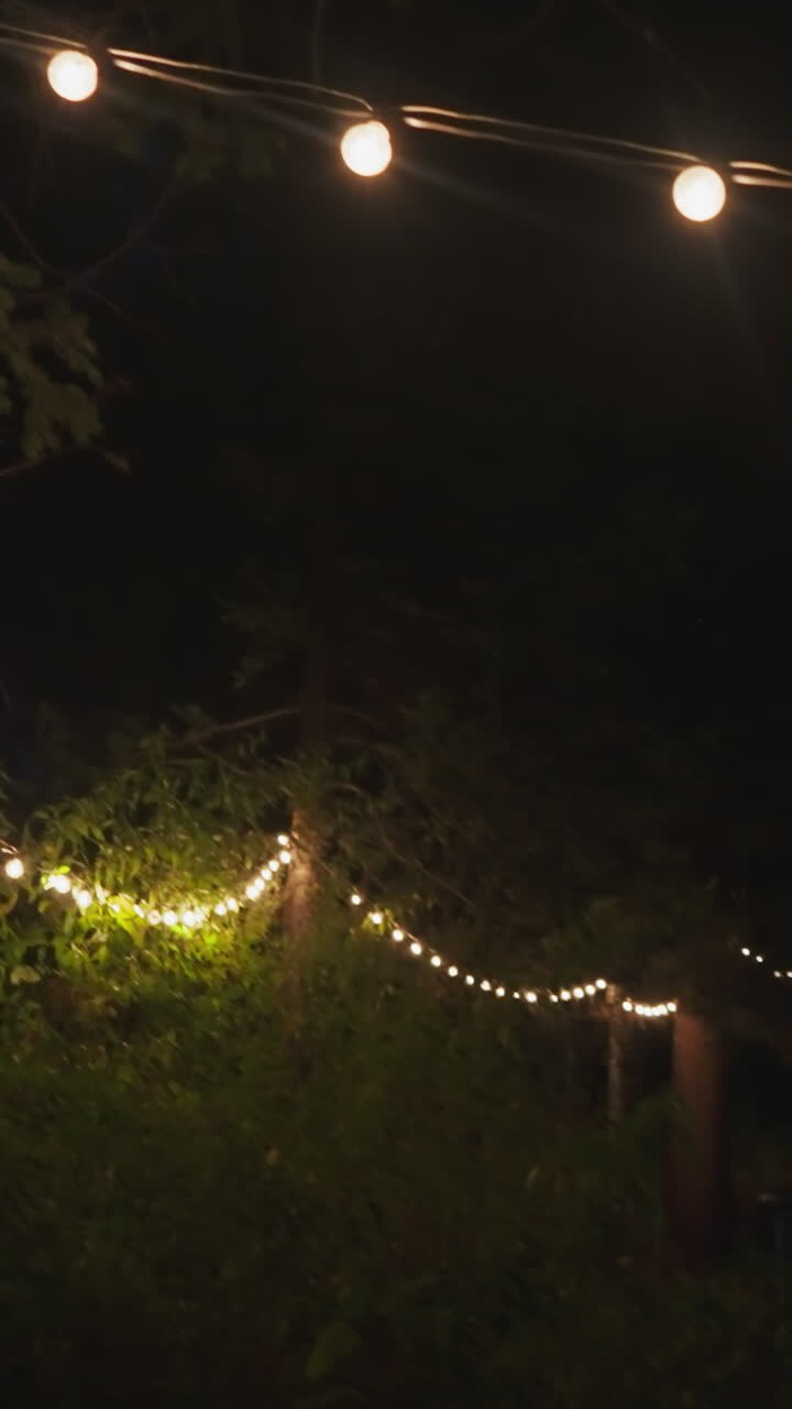 Illuminated with garlands courtyard at night. Country building for tourists to relax among dense forest of untouched nature. Modern accommodation for holiday