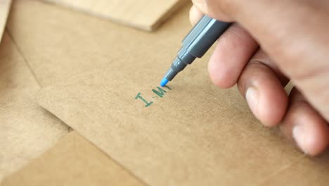 hand writing a message on cardboard notes