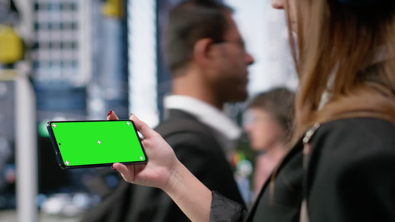 Smartphone orizzontale con chroma key tenuto da giovane adulto con headset