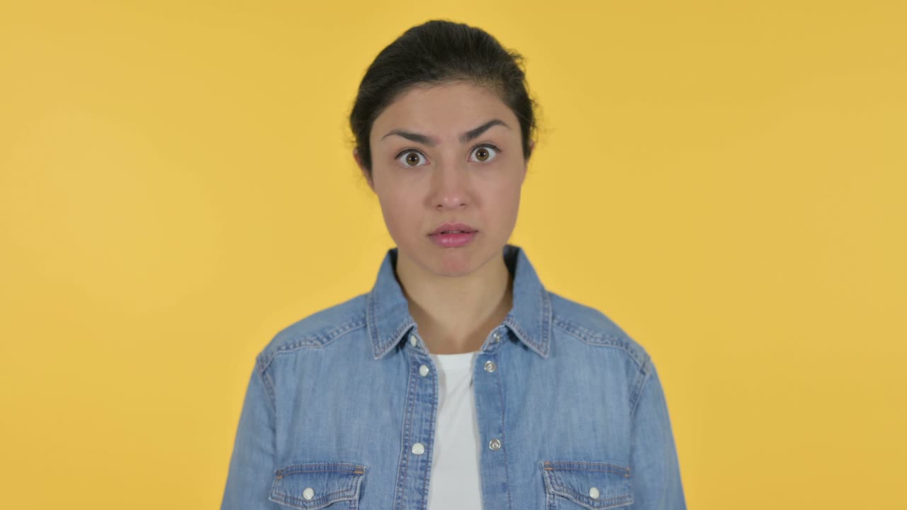 Shocked Young Indian Woman on Yellow Background