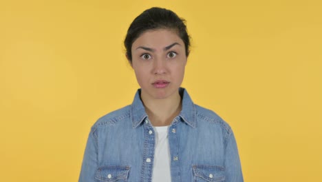 shocked young indian woman on yellow background