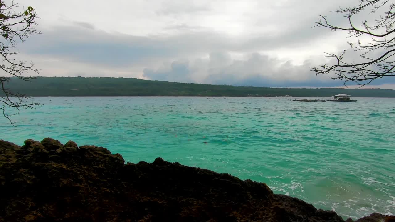 una vista dell'isola e acque blu sotto l'albero con cottage galleggianti