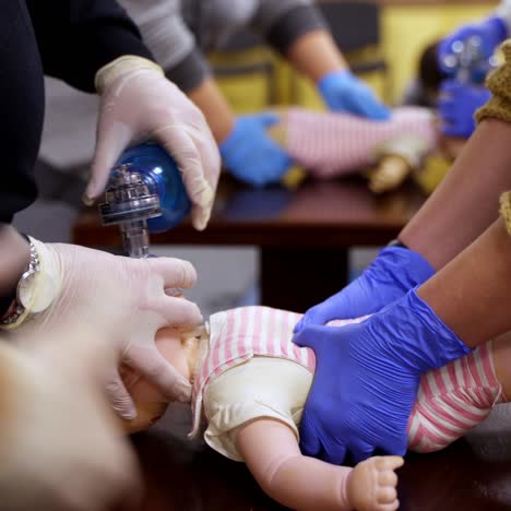 demonstrating chest compressions on medical infant dummy doll. simulator for training first aid. heart massage training. concept of medical education and practice