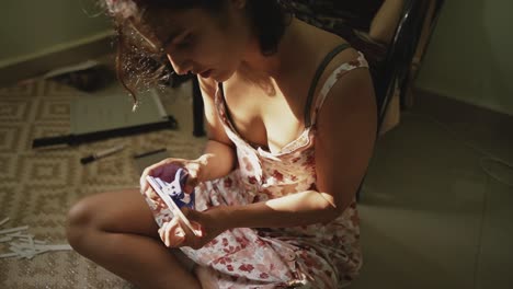 woman sitting cross legged using hole puncher to create craft project