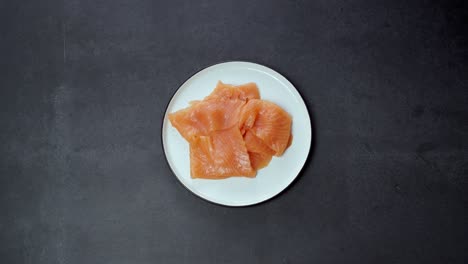 Las-Manos-Quitan-El-Plato-De-Salmón-Fresco-En-Rodajas