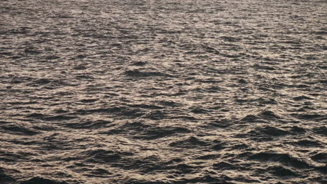 wavy open sea with sun reflecting off it in late afternoon from mainland malta to gozo