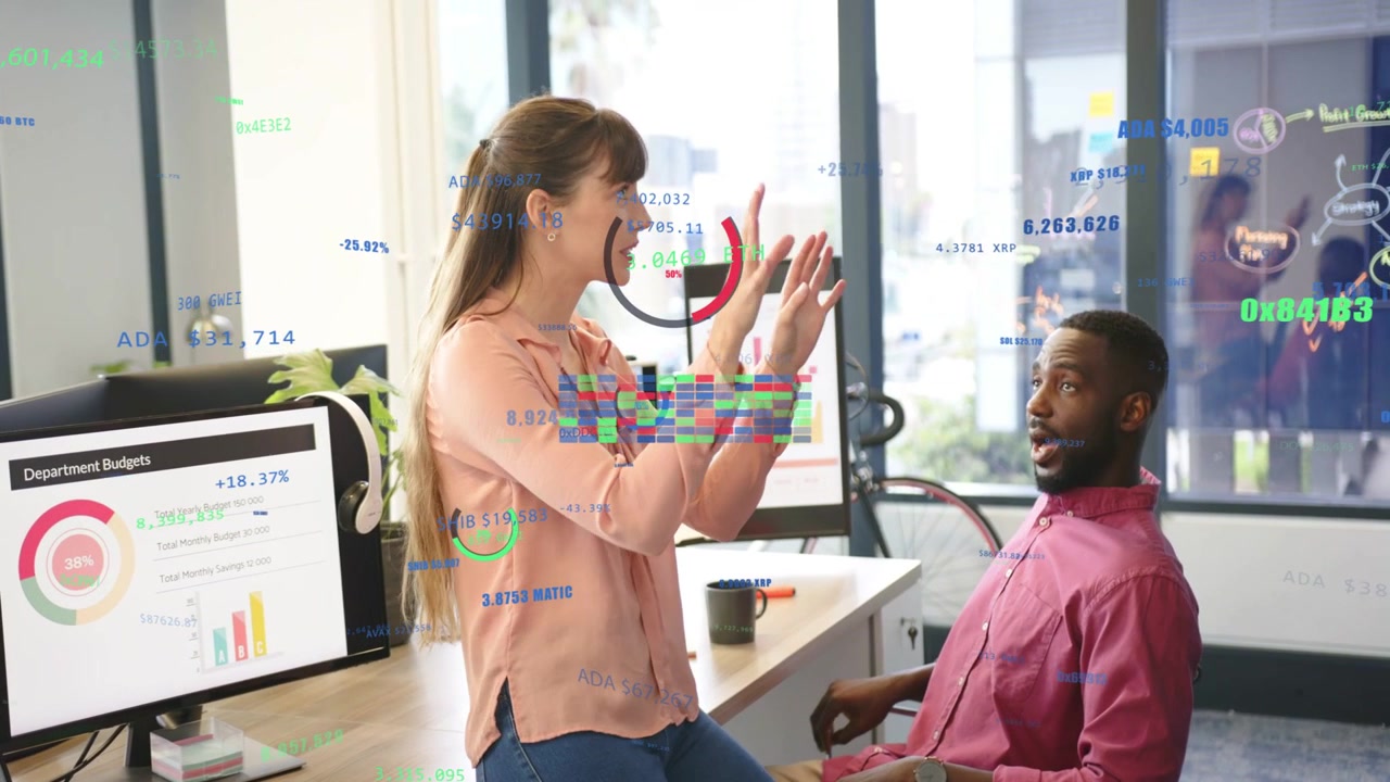 Woman leaning desk pointing monitors, causing budget overlays as man reacting and reviewing budgets