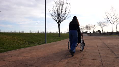 granddaughter assisting grandmother's park outing via wheelchai