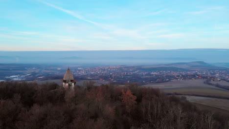 aerial zoom out of a viewpoint on a hill with sunrise in the background