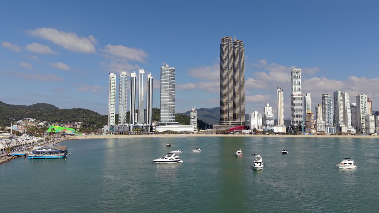Luxury yachts anchored along Balneario Camboriu coast, backed by stunning modern skyscrapers
