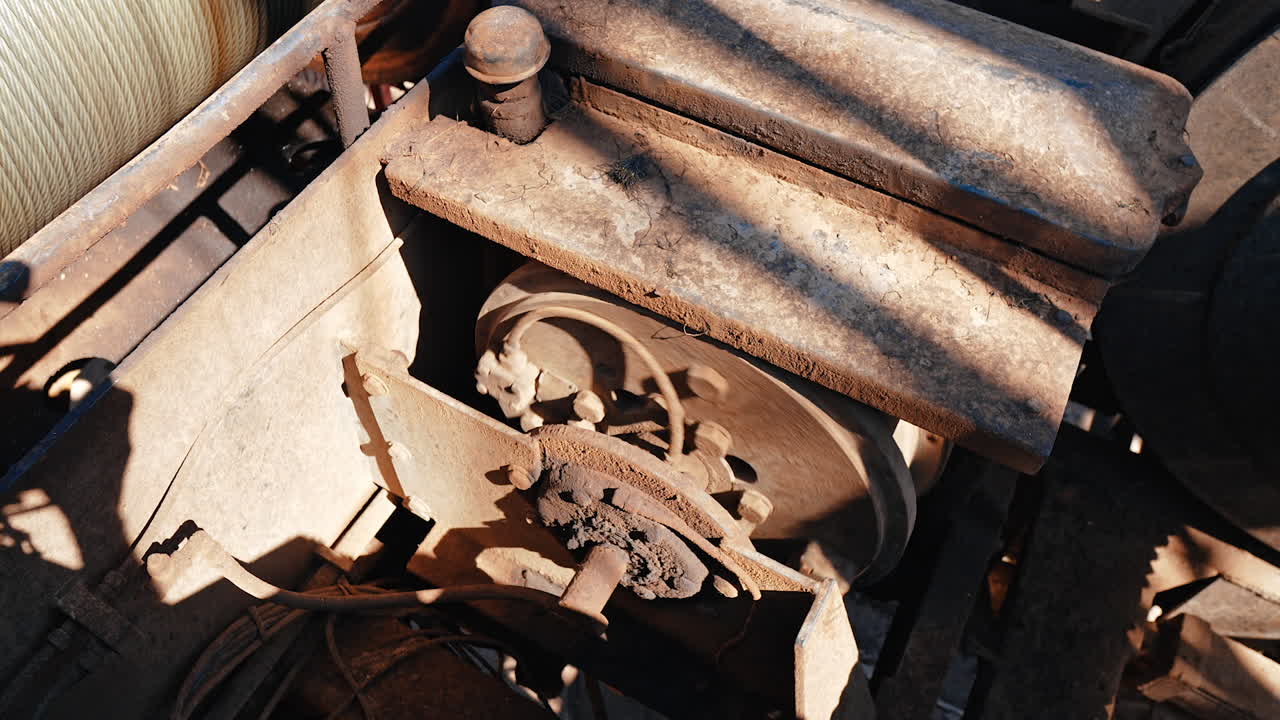 Machines covered with a layer of rust ad dirt are working. The rotating mechanism works in the equipment for production of gas or oil.