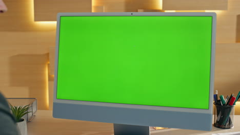 business person working on a computer with a green screen